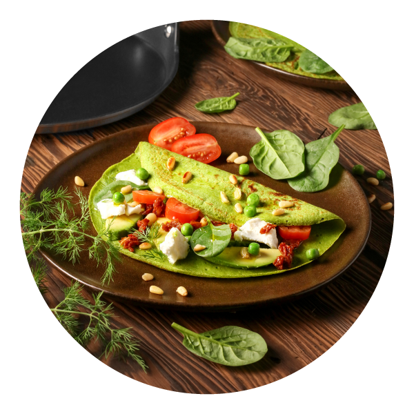 Zielony naleśnik z serem i warzywami na brązowym ceramicznym talerzu