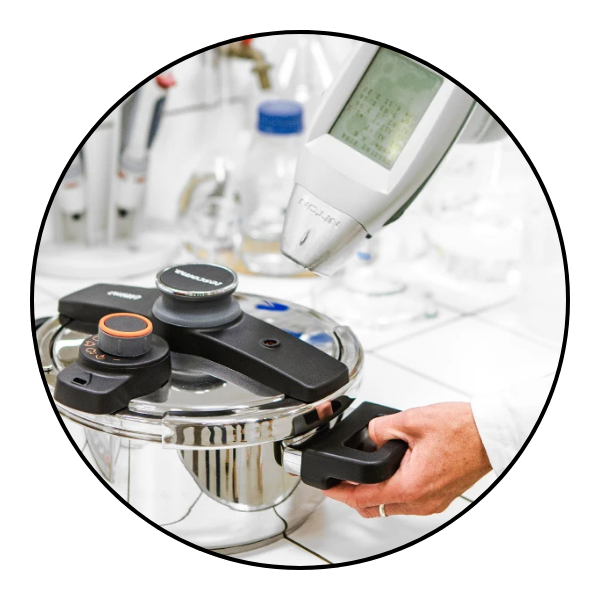 Zdjęcie przedstawia srebrny szybkowar z czarnymi elementami poddawany testom w laboratorium badawczym.