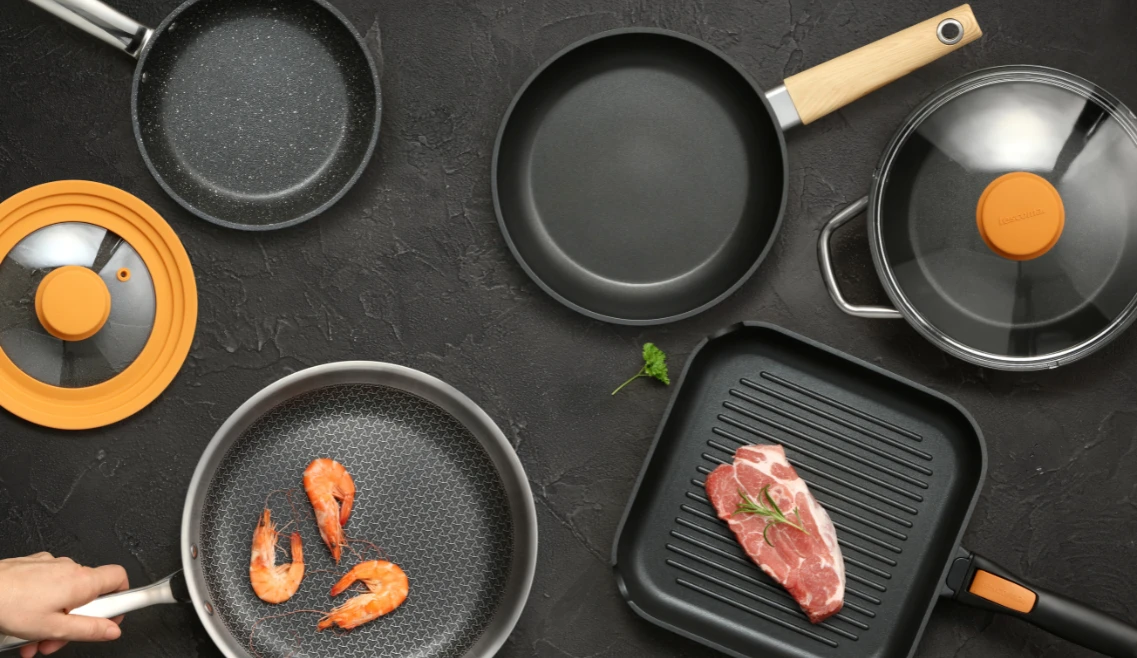 opis: widok z góry na różne patelnie z nieprzywierającą powłoką i pokrywki do patelni