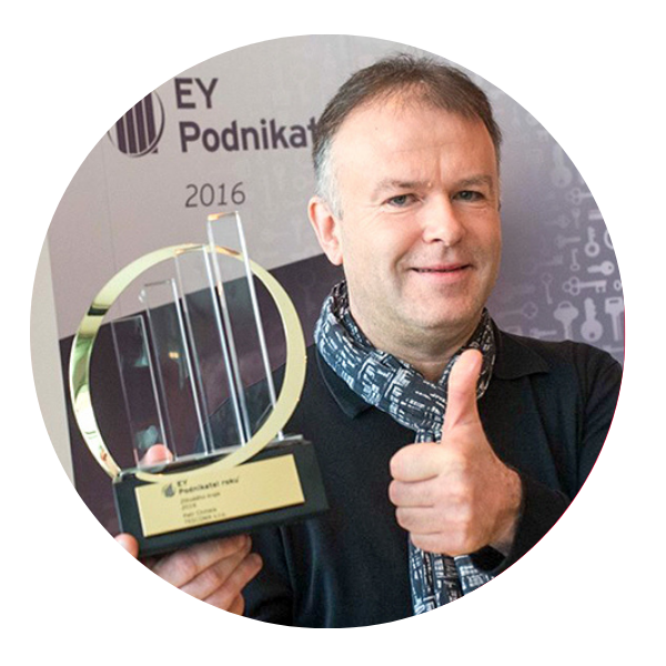 Opis: Petr Chmela pozuje ze statuetką i unosi kciuk.